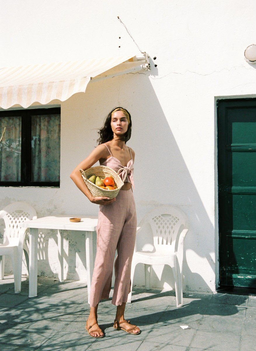 Femme rapportant un panier de fruits devant une maison méditerranéenne