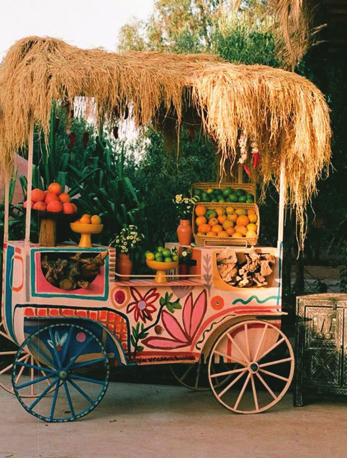 Charrette à fruits peinte sous un toit de paille